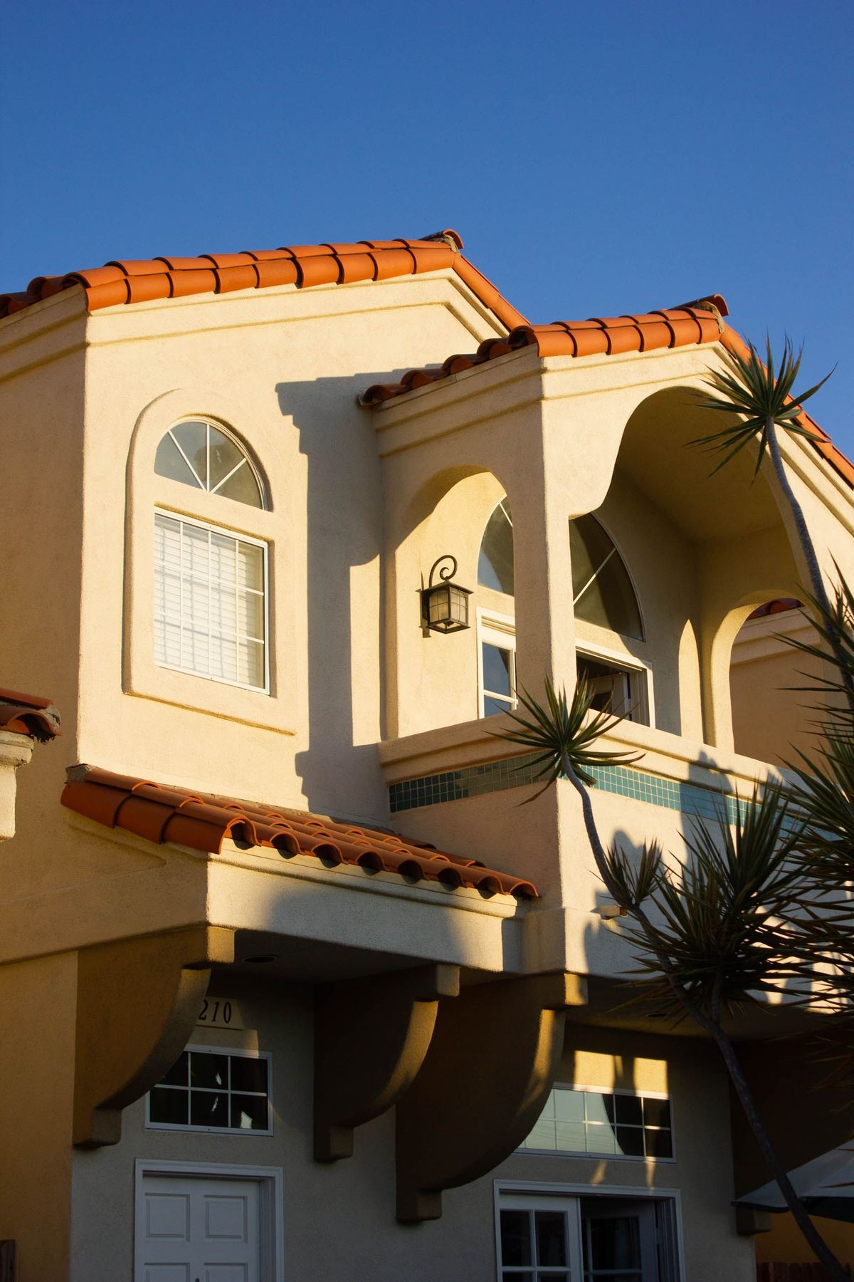 Mediterranean-style home with arched windows and terracotta roof tiles