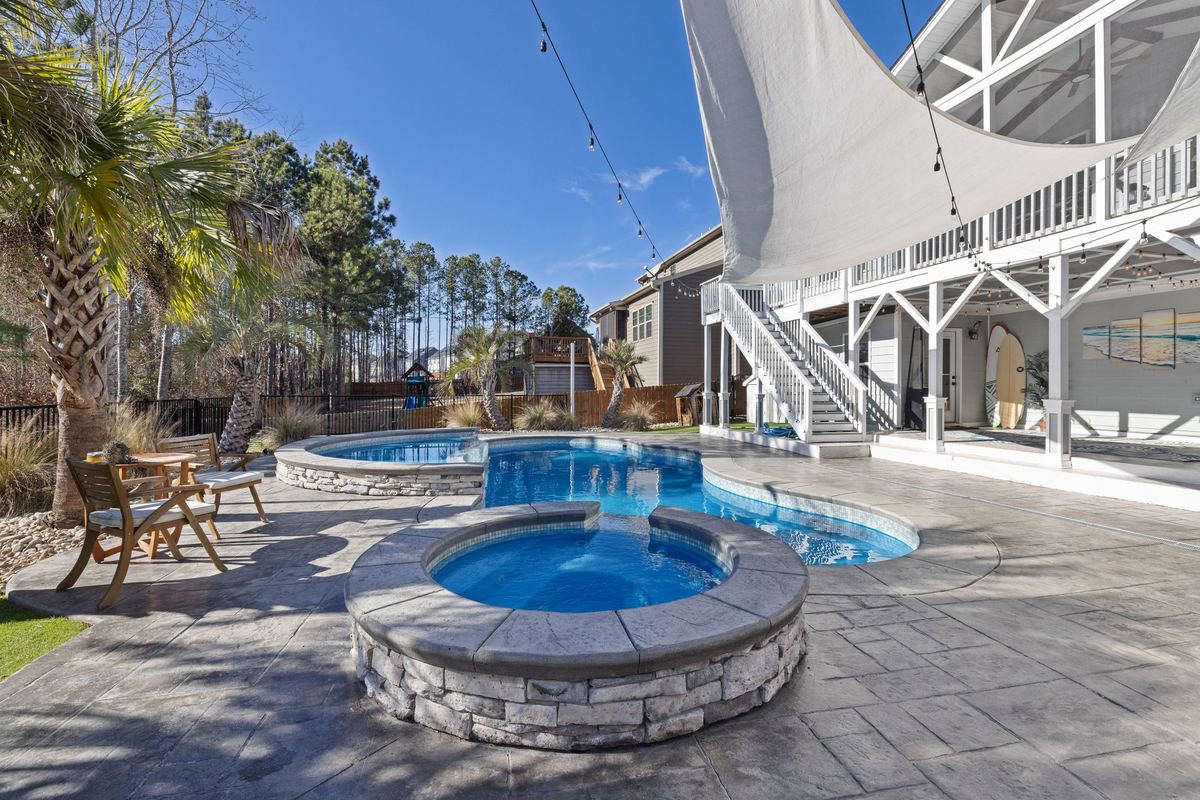 Backyard pool and raised spa with stone coping and paver decking