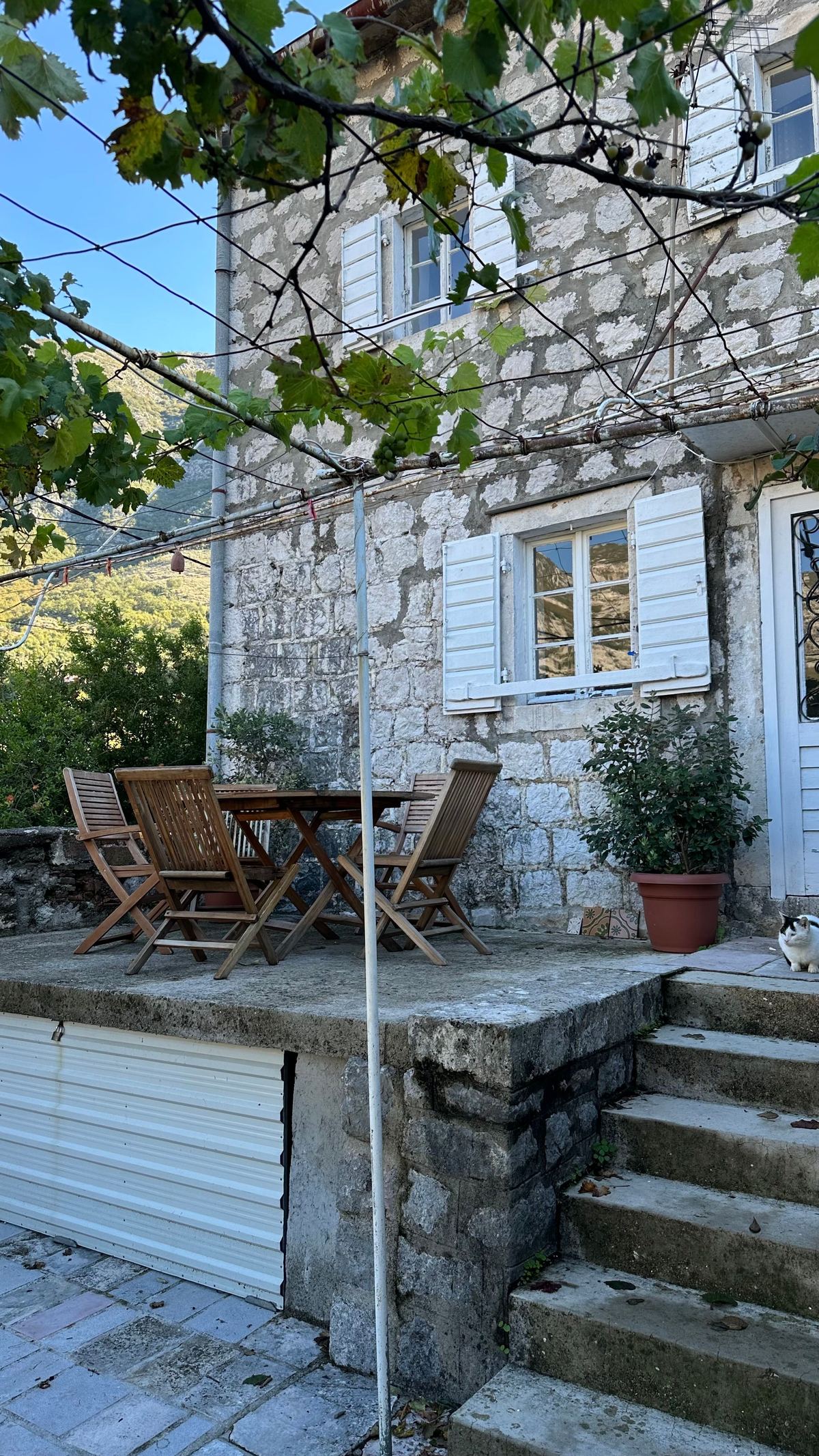 Stone-clad house with a small patio, steps and outdoor seating