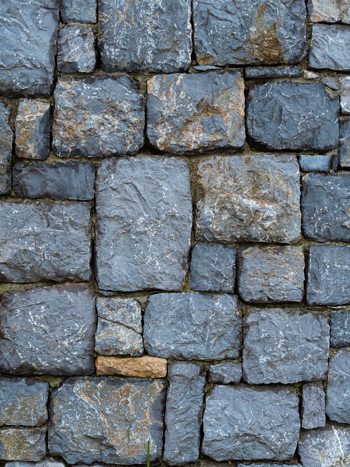 Blue-gray cut stone wall with rough-split faces