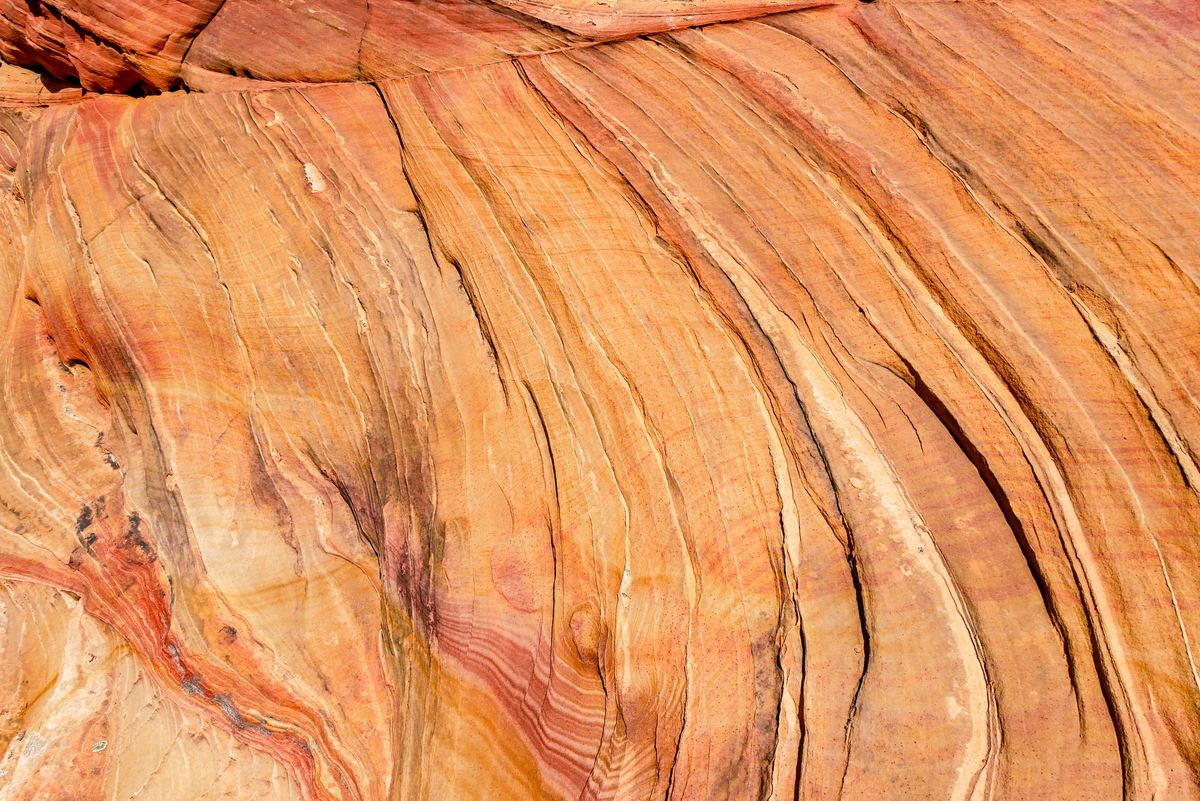 Layered sandstone showing natural bands of rust, cream and orange
